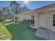 Front entrance of the home featuring a white door, landscaping and walkway at 5726 Autumn Shire Dr, Zephyrhills, FL 33541