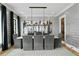 Formal dining room with gray chairs, marble table, and linear chandelier at 5811 Mariner St, Tampa, FL 33609