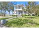 Charming two-story white home with a welcoming front porch and lush green lawn, perfect for serene living at 5811 Mariner St, Tampa, FL 33609
