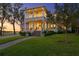 Charming two-story home with a welcoming front porch and beautifully landscaped front yard at dusk at 5811 Mariner St, Tampa, FL 33609