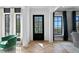 Elegant foyer featuring hardwood floors, stylish black front door, and windows offering serene outdoor views at 5811 Mariner St, Tampa, FL 33609