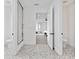 Hallway with a view to two bathrooms and a bedroom, featuring stylish tile flooring at 5811 Mariner St, Tampa, FL 33609