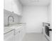 Bright laundry room featuring a large sink, counter space, and modern washer and dryer at 5811 Mariner St, Tampa, FL 33609