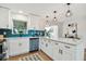 Updated kitchen featuring white cabinets, quartz countertops, and teal tile backsplash at 10721 64Th Ave, Seminole, FL 33772