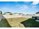 Large grassy backyard enclosed by a light beige fence at 17036 Peaceful Valley Dr, Wimauma, FL 33598