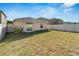 Large backyard with grassy area, privacy fence, and adjacent houses at 17036 Peaceful Valley Dr, Wimauma, FL 33598