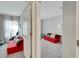 Cozy bedroom with red couch and window with sheer curtains at 17036 Peaceful Valley Dr, Wimauma, FL 33598