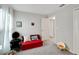 Bright bedroom with red couch and window at 17036 Peaceful Valley Dr, Wimauma, FL 33598