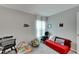 Bedroom with red couch, chair, and play area at 17036 Peaceful Valley Dr, Wimauma, FL 33598