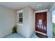 Front entry with a brown door and side window at 17036 Peaceful Valley Dr, Wimauma, FL 33598