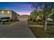 One story house exterior at dusk with a two-car garage at 17036 Peaceful Valley Dr, Wimauma, FL 33598