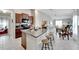 Open kitchen features island with seating, granite countertops, and dark wood cabinets at 17036 Peaceful Valley Dr, Wimauma, FL 33598