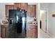 Black appliances and wood cabinets in this kitchen at 17036 Peaceful Valley Dr, Wimauma, FL 33598