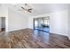 Bright living room with wood-look floors and sliding glass doors leading to a screened porch at 1715 S Pebble Beach Blvd, Sun City Center, FL 33573