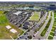 Aerial view showcasing community amenities including the lawn bowling, recreation facilities, and lake at 1715 S Pebble Beach Blvd, Sun City Center, FL 33573