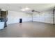 Spacious garage with epoxy flooring, overhead door, storage, and room for multiple cars at 1715 S Pebble Beach Blvd, Sun City Center, FL 33573