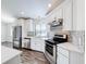 Modern kitchen featuring white cabinets, stainless steel appliances, and stylish backsplash, perfect for cooking at 1715 S Pebble Beach Blvd, Sun City Center, FL 33573