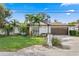 White single-story home with brown roof, palm trees, and landscaped lawn at 3401 W North B St, Tampa, FL 33609