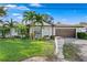 White single-story home with brown roof, palm trees, and landscaped lawn at 3401 W North B St, Tampa, FL 33609