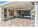 Covered porch with paver flooring and screened enclosure at 37635 Gill Ave, Zephyrhills, FL 33541