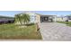 Front view of a single story home with a paved driveway and landscaping at 37635 Gill Ave, Zephyrhills, FL 33541