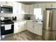 Renovated kitchen with white cabinets, stainless steel appliances, and tile flooring at 1114 Palm Bluff St, Clearwater, FL 33755