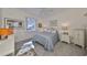 Bright bedroom with a queen bed, wood nightstands, and a window at 1120 Emerald Dunes Dr, Sun City Center, FL 33573