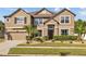 Two-story house with beige facade, dark brown accents, and a three-car garage at 11818 Gilmerton Dr, Riverview, FL 33579