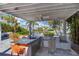 Covered outdoor kitchen with grill, sink, and bar seating at 16434 Redington Dr, Redington Beach, FL 33708