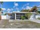 Gray mid-century modern home with screened porch and landscaped yard at 16434 Redington Dr, Redington Beach, FL 33708