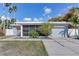 Mid-century modern home with screened porch and attached garage at 16434 Redington Dr, Redington Beach, FL 33708
