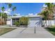 Mid-century modern home with attached garage and landscaped yard at 16434 Redington Dr, Redington Beach, FL 33708