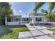 Modern backyard with outdoor kitchen, patio, and fire pit at 16434 Redington Dr, Redington Beach, FL 33708
