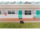 Exterior view of building showing teal doors and landscaping at 1950 59Th N Ave # 114, St Petersburg, FL 33714