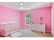 Charming bedroom with pink walls, crib, and dresser at 2012 Deltona Blvd, Spring Hill, FL 34606