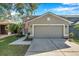 Two-story house with gray siding, two-car garage, and landscaped yard at 7753 Foxgrove Dr, Land O Lakes, FL 34637