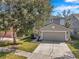 Two-story house with gray siding, two-car garage, and landscaped yard at 7753 Foxgrove Dr, Land O Lakes, FL 34637