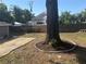 Backyard featuring mature trees, wooden fencing, landscaping, and a gravel area, creating a private outdoor space at 1003 W Mahoney St, Plant City, FL 33563