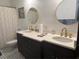 Bathroom with double vanities, dark wood cabinets, and black and white tiled floor at 1003 W Mahoney St, Plant City, FL 33563