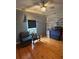 Bedroom with wood floors, chair, and decorative brick accent wall, illuminated by a ceiling fan and natural light at 1003 W Mahoney St, Plant City, FL 33563