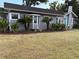 Charming single-story home with gray siding, mature landscaping, and an inviting turquoise front door at 1003 W Mahoney St, Plant City, FL 33563