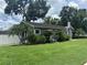 Charming one-story home with a well-maintained lawn and landscaped with decorative tropical plants and mature trees at 1003 W Mahoney St, Plant City, FL 33563