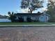 Inviting single-story home featuring a classic brick road, well-manicured lawn, and a quaint turquoise door at 1003 W Mahoney St, Plant City, FL 33563