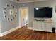 Living room featuring hardwood floors, white cabinet, large screen tv and Gathering photos on wall at 1003 W Mahoney St, Plant City, FL 33563