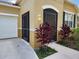 Front entrance with a screened-in porch and tropical landscaping at 107 Slipper Key Rd, Apollo Beach, FL 33572