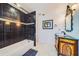 Modern bathroom with dark tile, white tub, and ornate vanity at 1135 Candler Rd, Clearwater, FL 33765