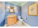 Bathroom with blue patterned wallpaper, vanity, and decorative framed art at 1135 Candler Rd, Clearwater, FL 33765