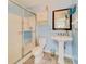 Clean and bright bathroom with a shower, pedestal sink, and frosted glass door at 1135 Candler Rd, Clearwater, FL 33765