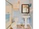 Well-lit bathroom with a pedestal sink, glass shower door and frosted glass window at 1135 Candler Rd, Clearwater, FL 33765