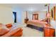 Second bedroom with stylish four-poster bed, leather chair, and soft carpet at 1135 Candler Rd, Clearwater, FL 33765